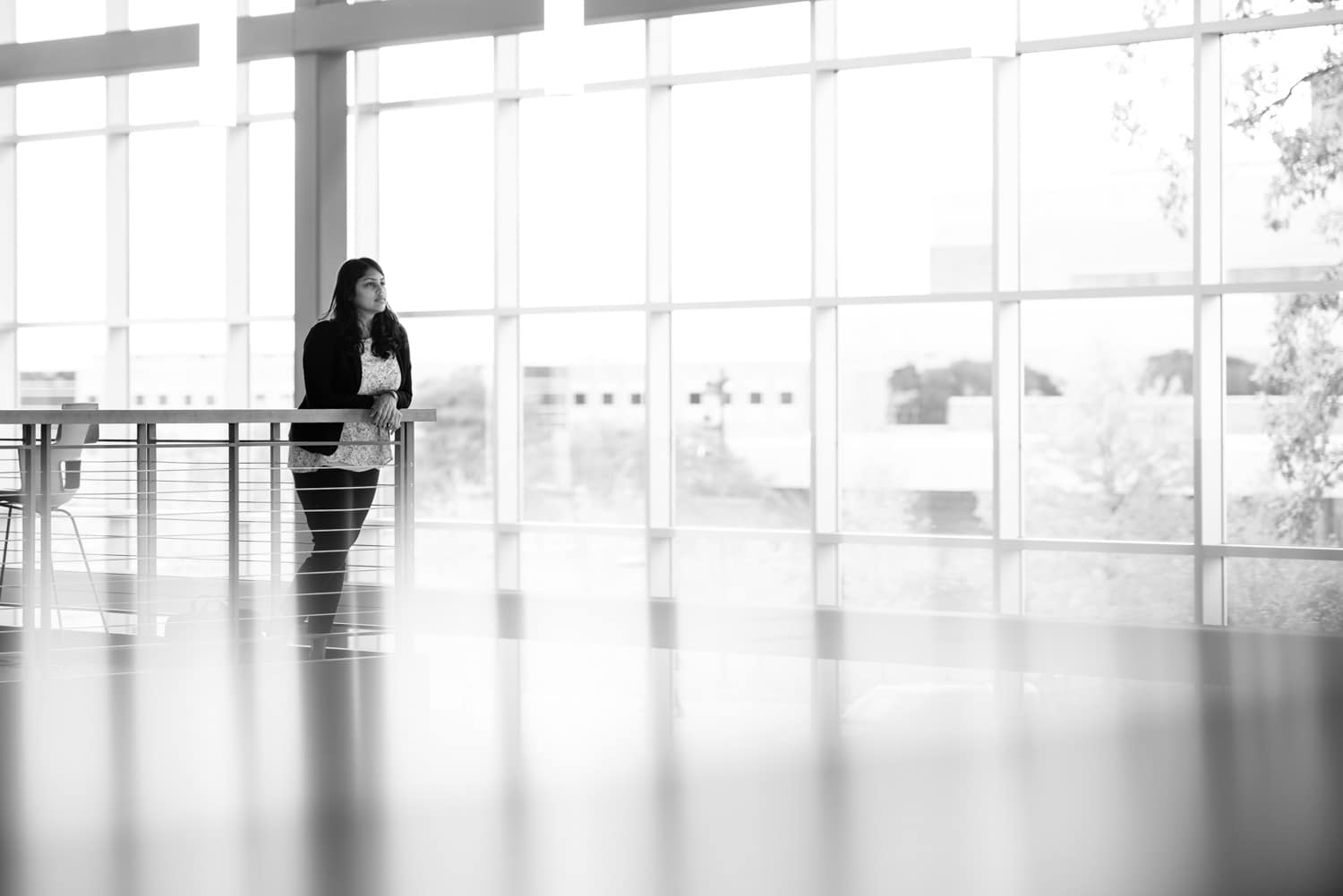  Student standing on ledge in room with big windows. 