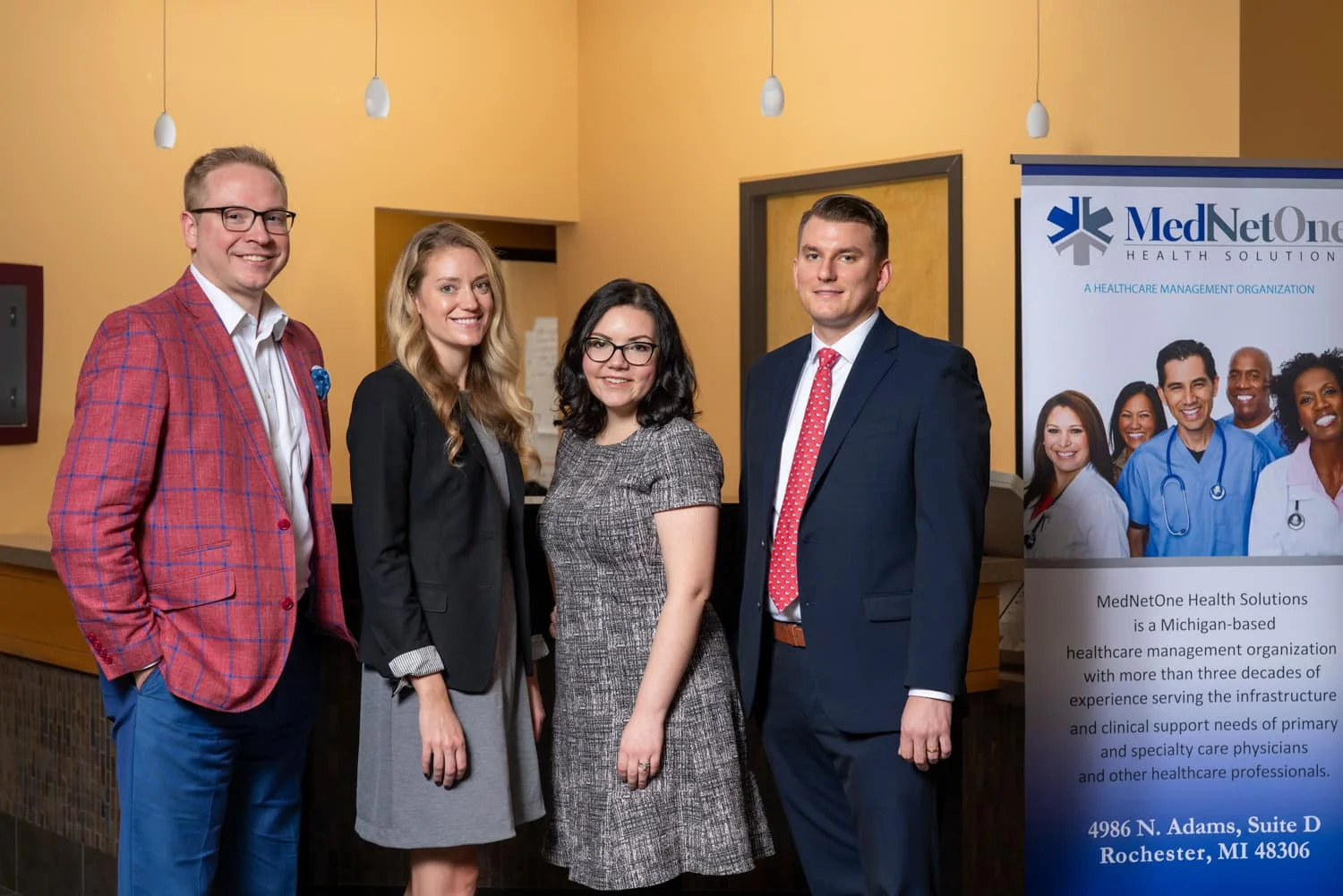 4 former students standing in an office