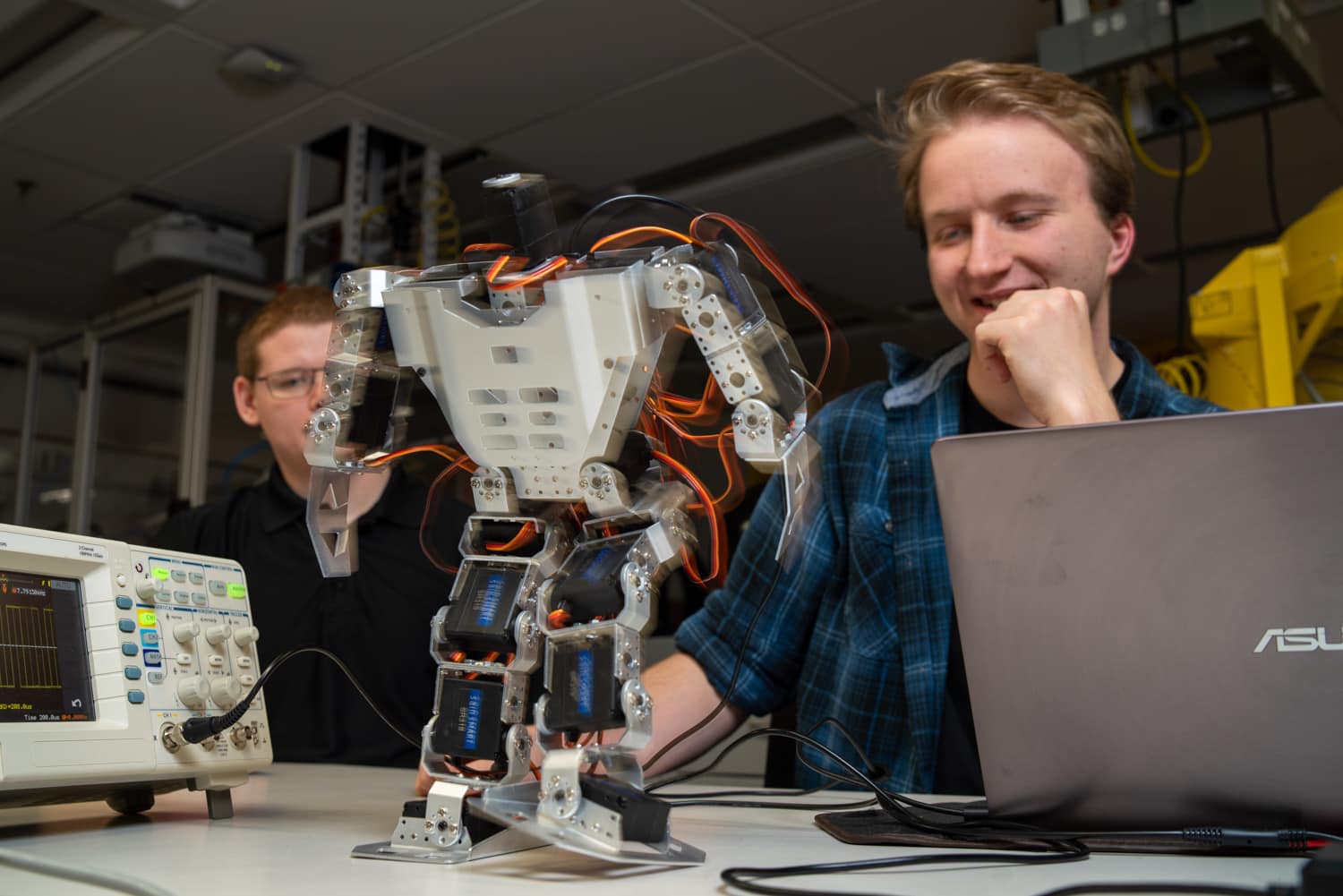  student watching walking robot 