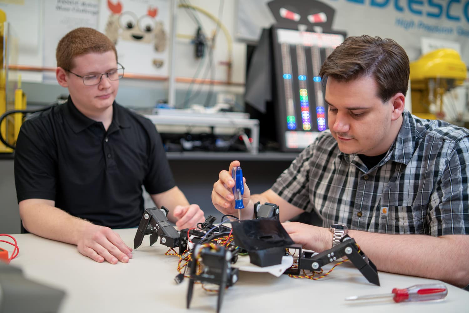  2 oakland university students working on a roboto 