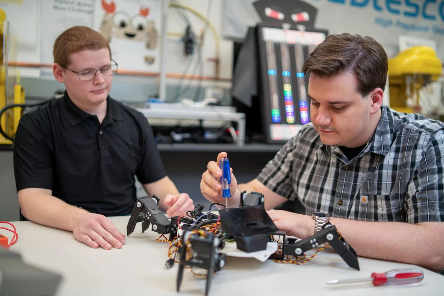 2 oakland university students working on a roboto