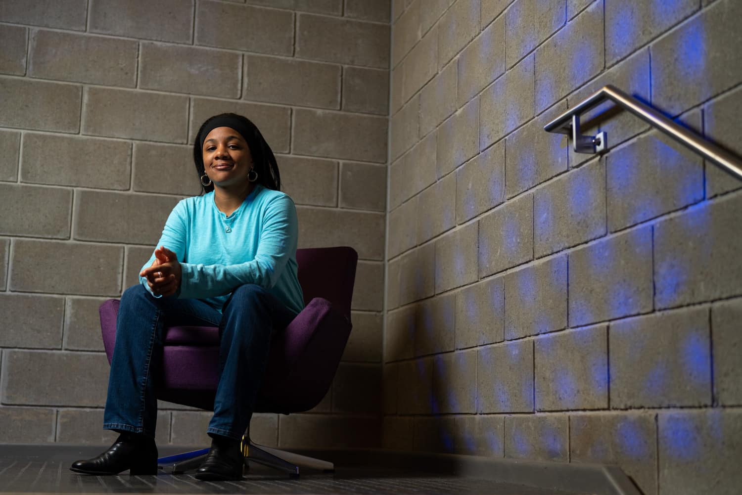  student sitting in chair in front of brick wall 