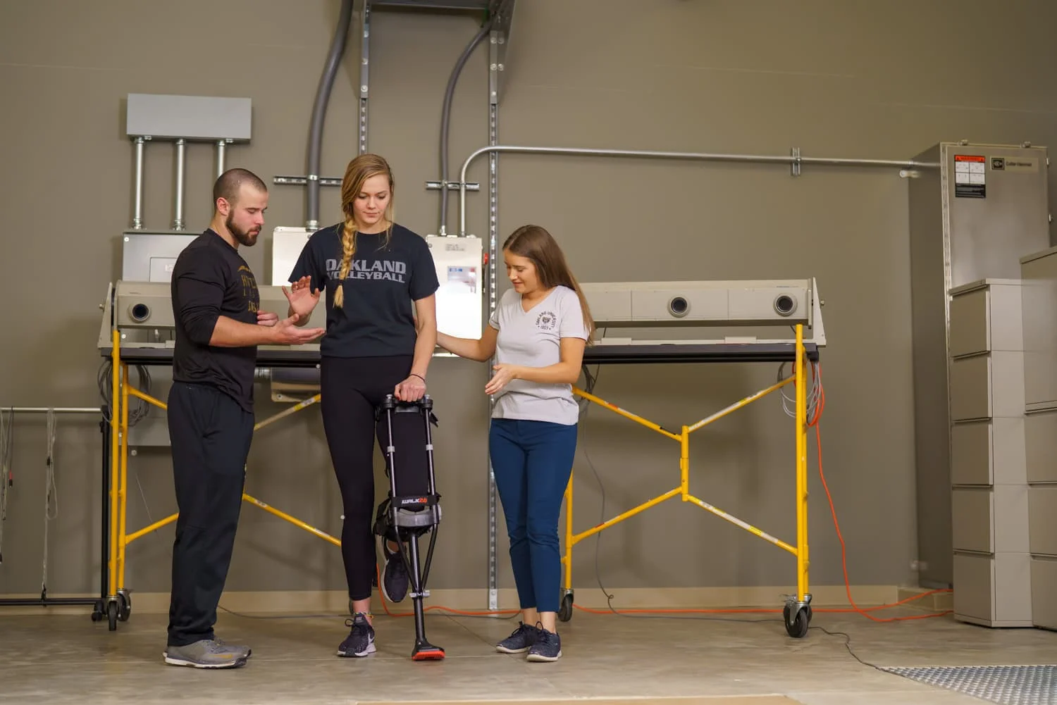 students assisting athlete while monitoring balance