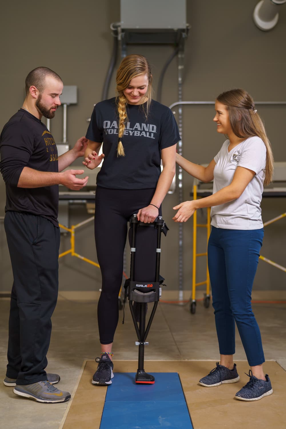  students assisting athlete while monitoring balance 