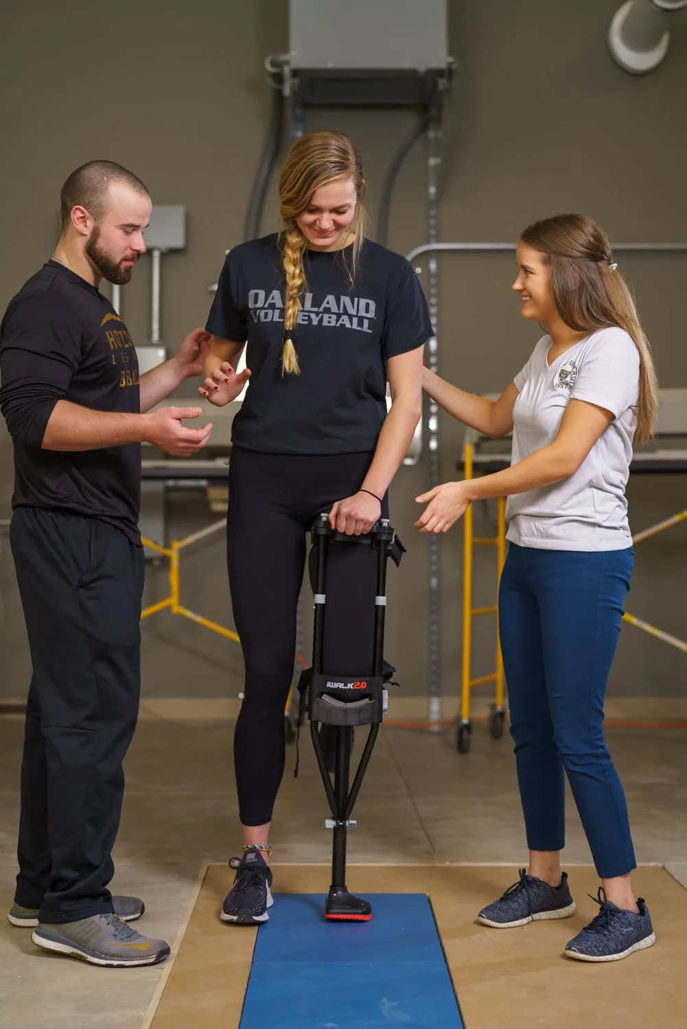 students assisting athlete while monitoring balance