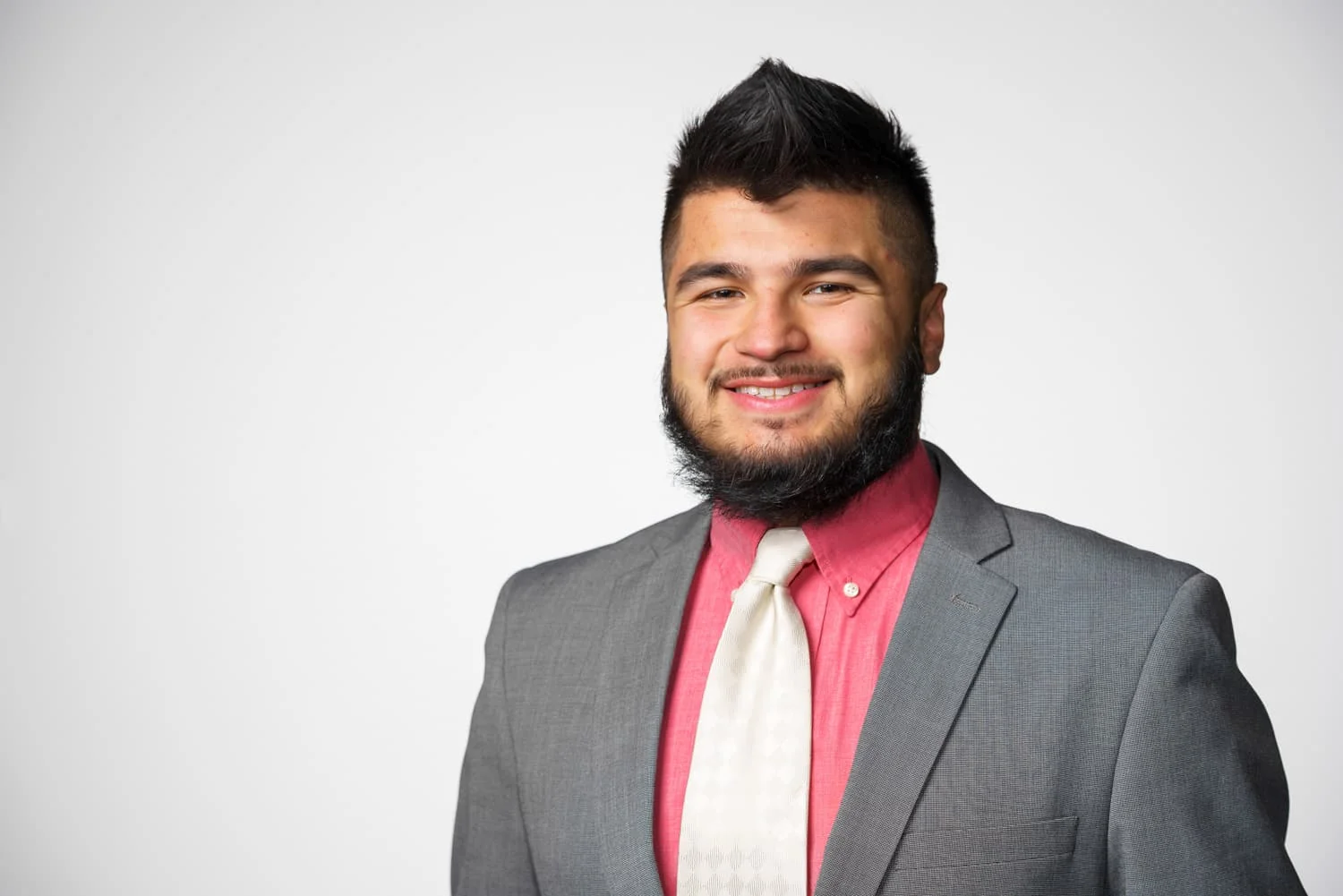 portrait of student in gray suit pink shirt and white tie