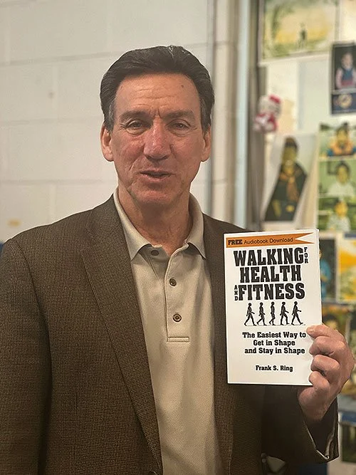 Frank S. Ring holding one of his walking and fitness books, author and coach supporting men through prostate cancer
