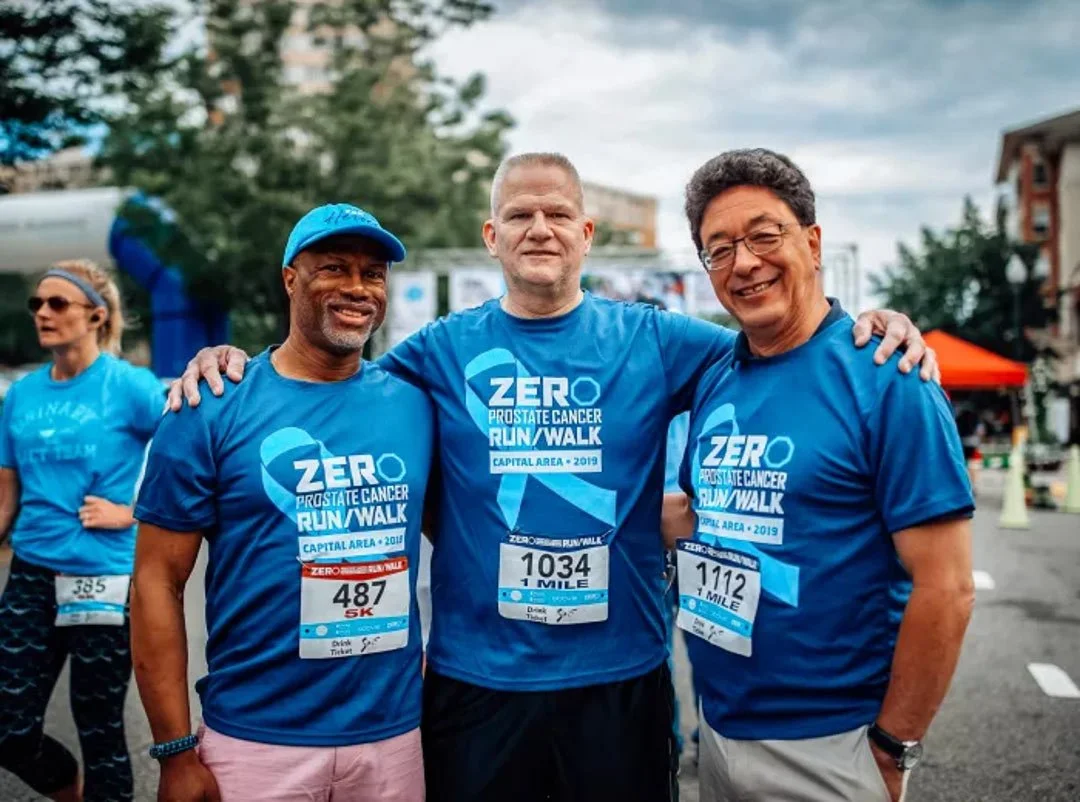 Three men together after a group walk, symbolizing support and resilience during cancer treatment.
