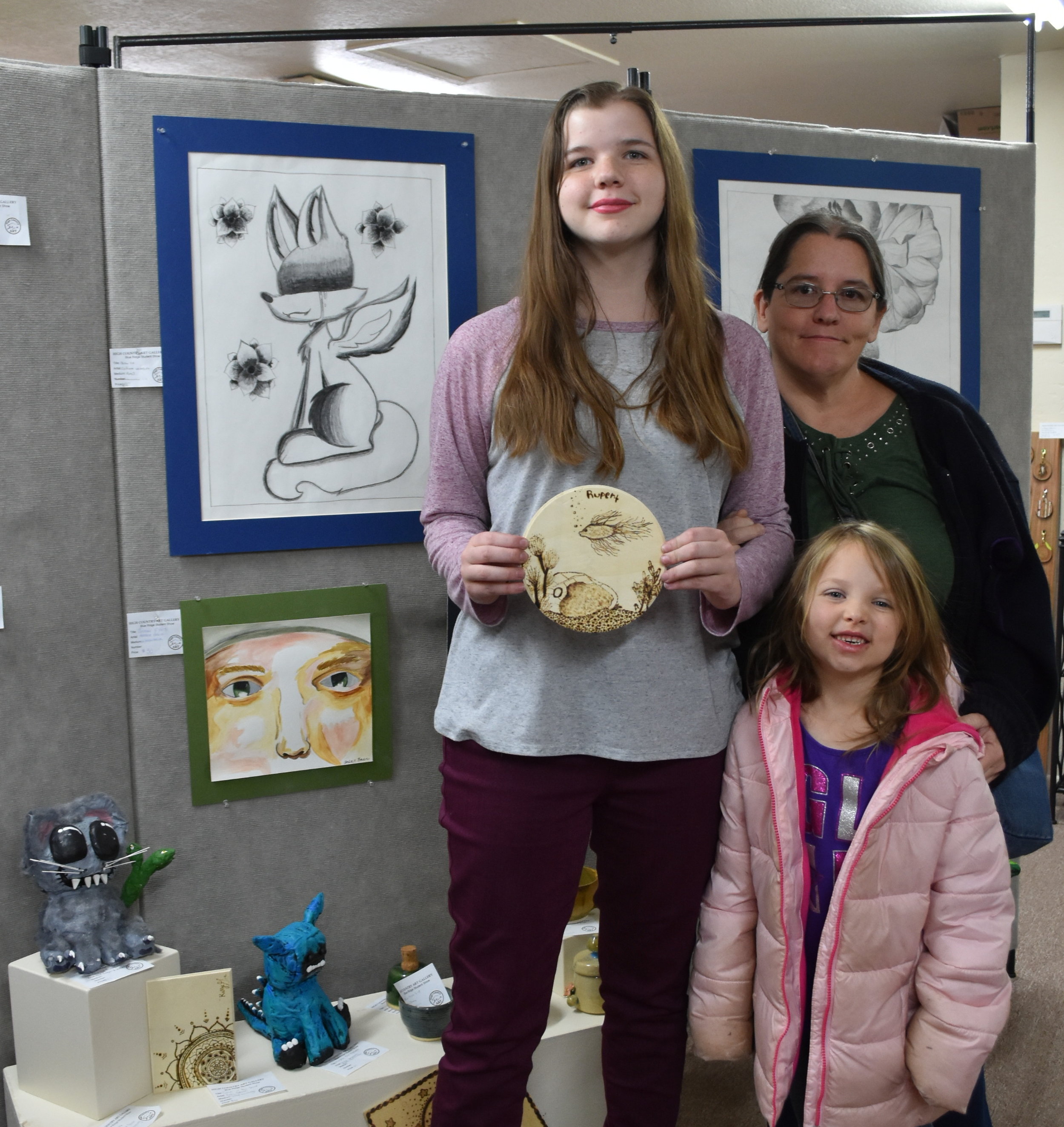 Copy of Amber Baer and Family, Amber holding one of her wood burning pieces.