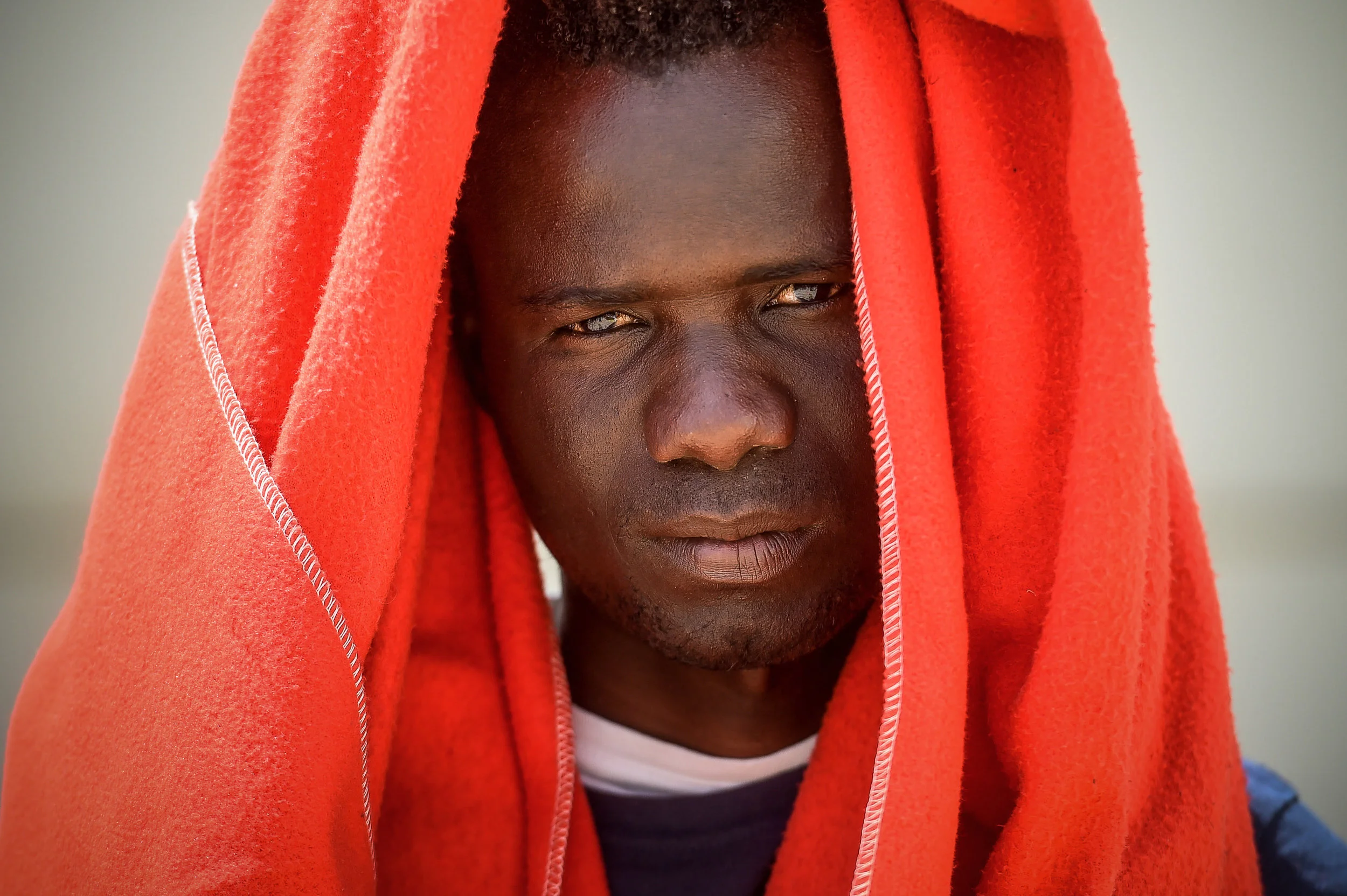  A refugee shelters from the sun under a blanket at the Los Cortijillos reception centre in Algeciras, Spain. 