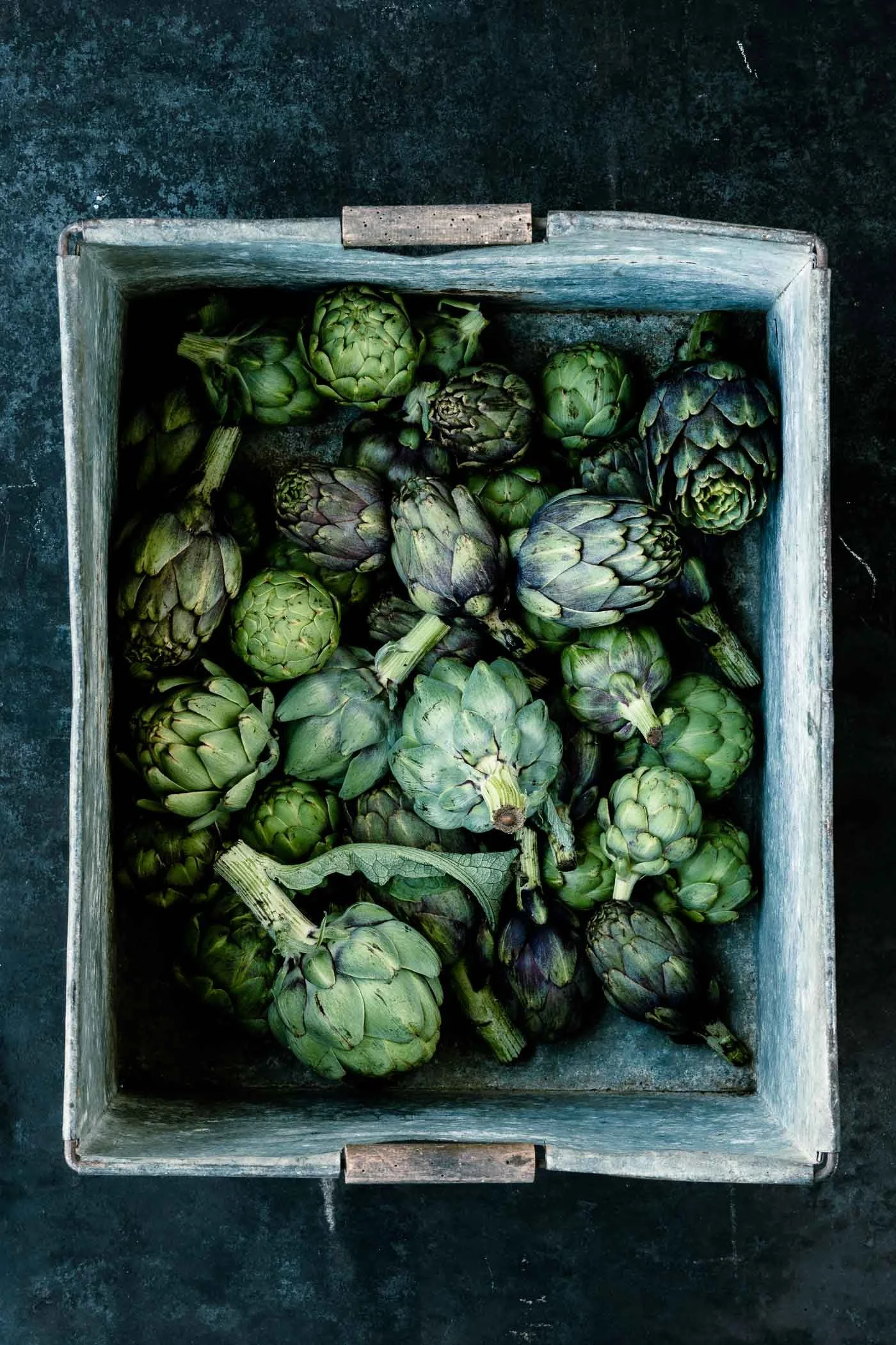 Artischocken unterschiedlicher Größe in einer Metallkiste - veggielicious.de