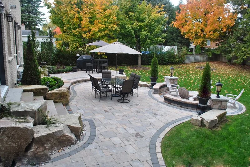 An inviting paver patio provides plenty of room for daily activities while special events can easily spill into the well-kept lawn.