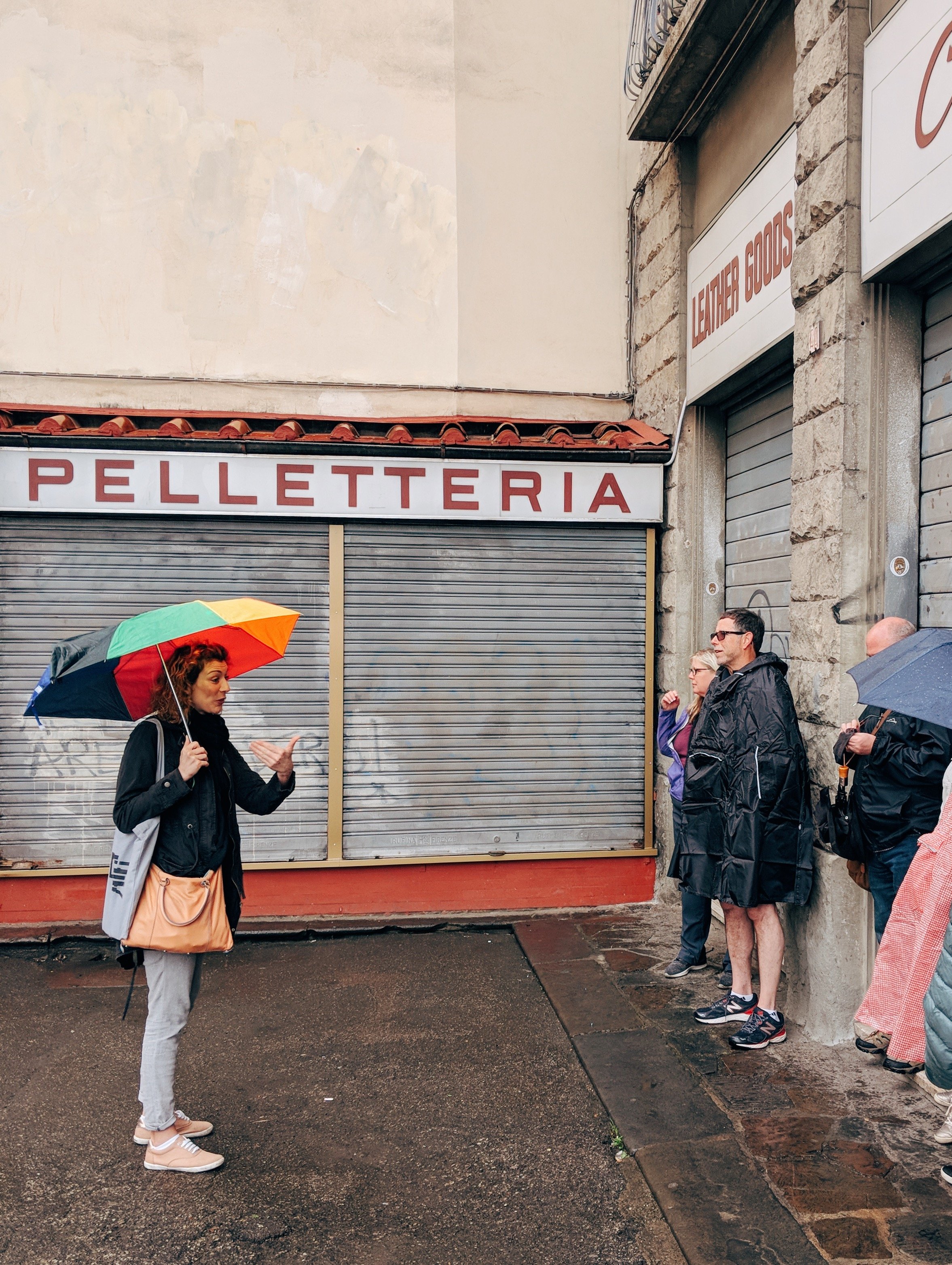 Woman holding umbrella leading a group tour