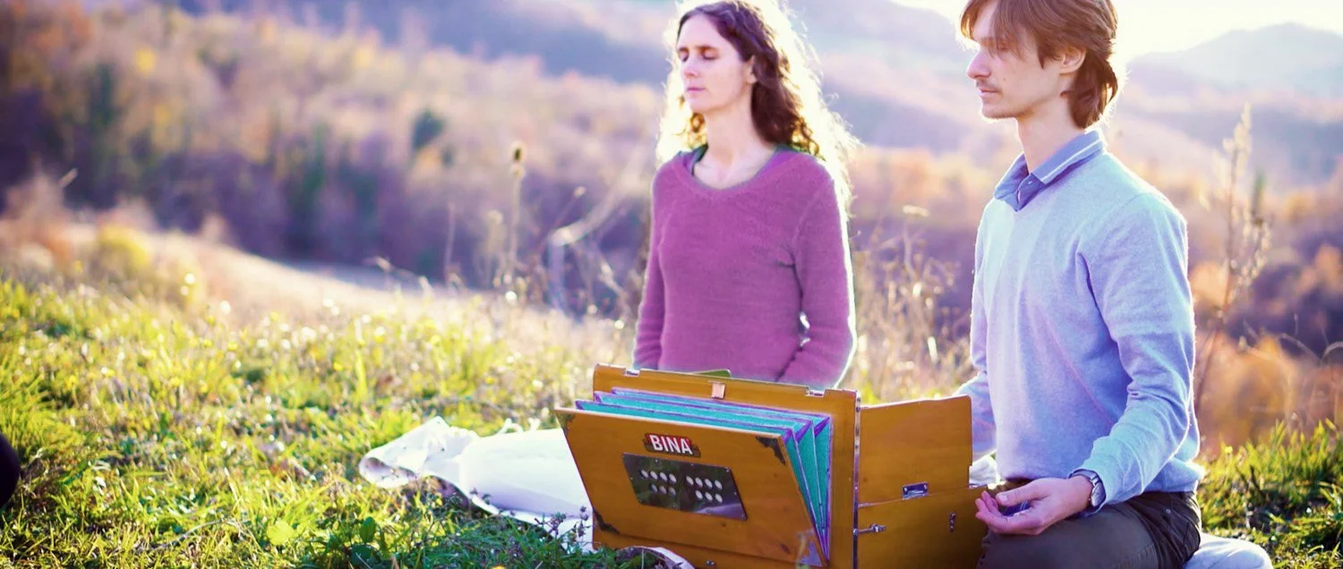 Mahiya and Arudra meditating with harmonium outdoors.jpg