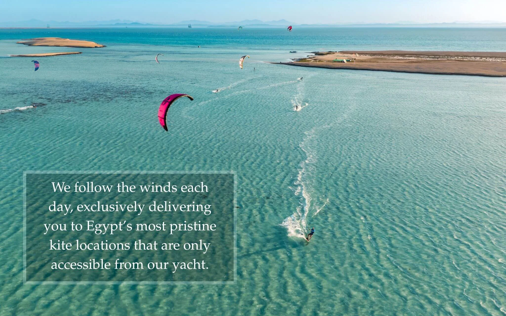 Premium beach setup with shade umbrellas and zodiac boat transfers on a private Red Sea kitesurfing island.