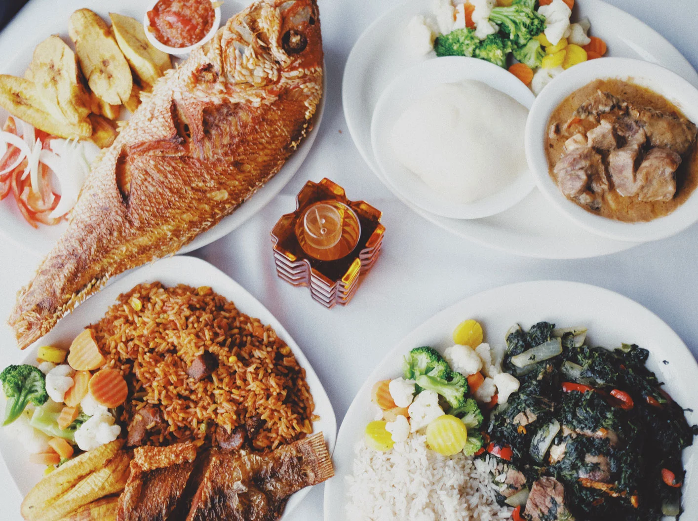 Jollof rice, fried spinach, peanut butter soup, fufu, fried snapper