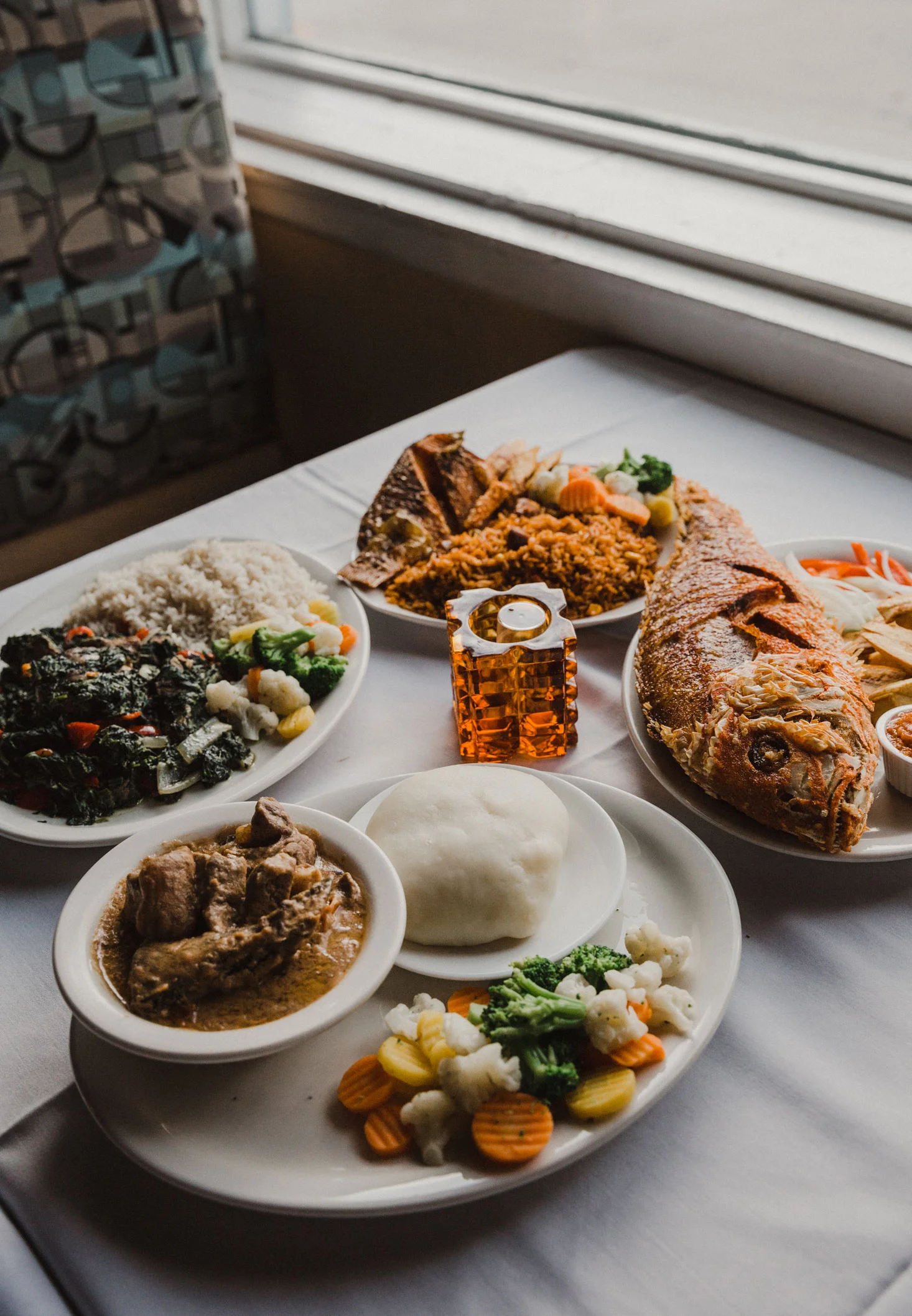 Peanut butter soup, fufu, fried snapper, jollof rice, fried spinach