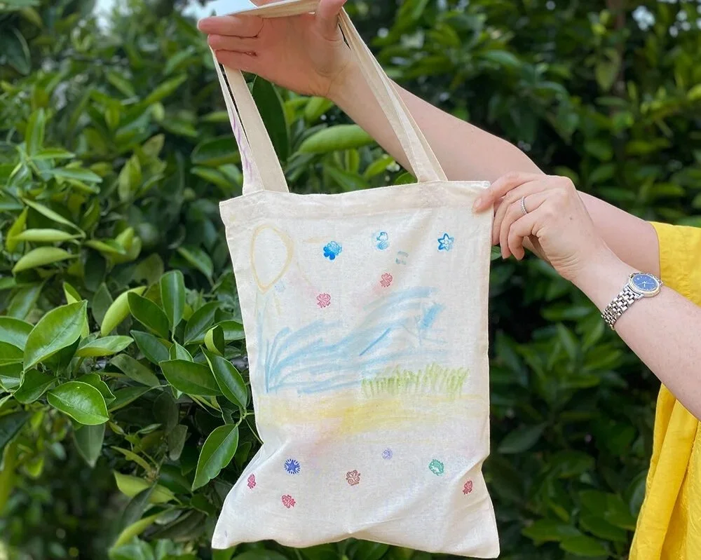 decorated tote bag agaisnt leafy green backdrop