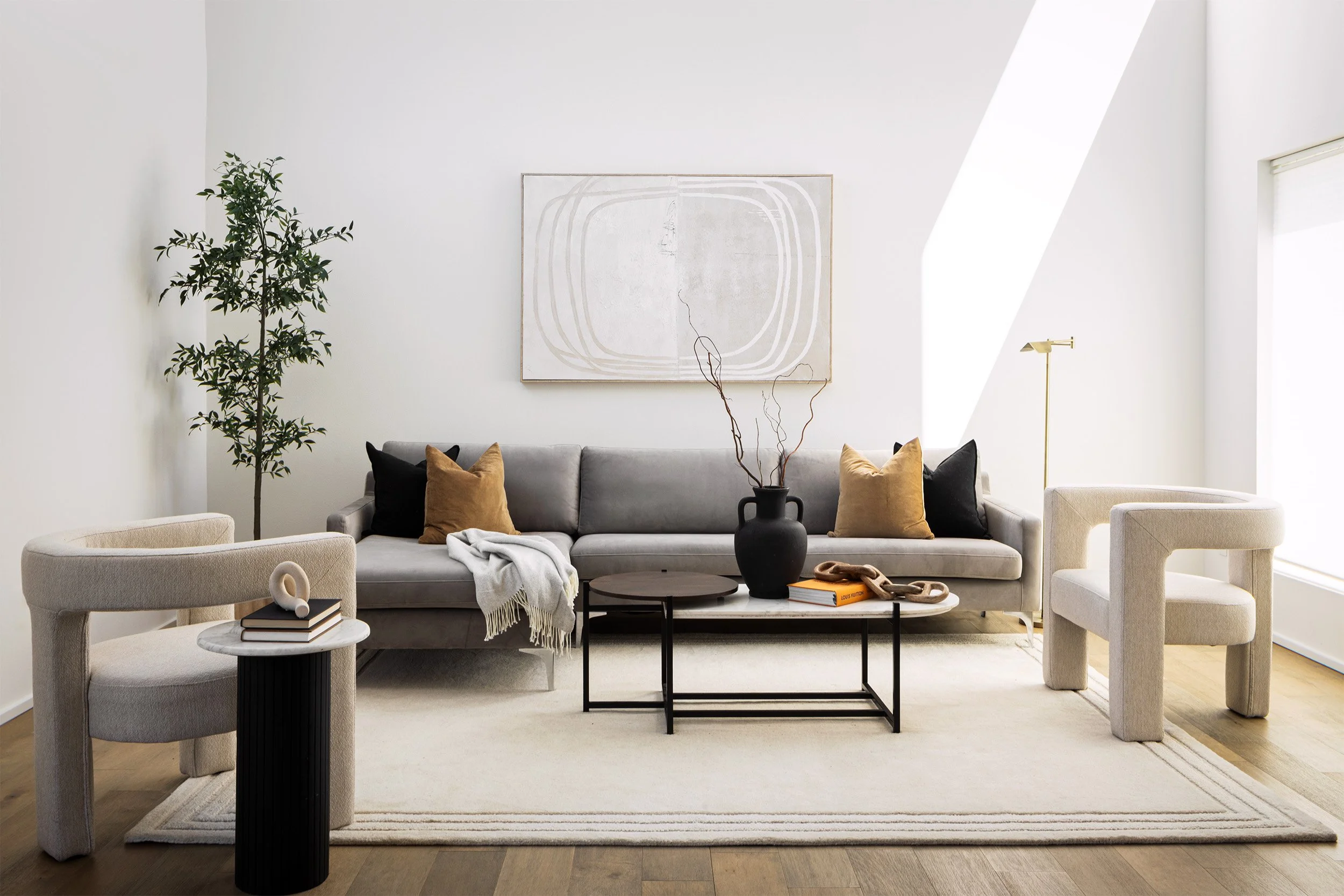 Minimal modern residential living room interior with gray sofa, sculptural lounge chairs, and neutral decor, Seattle interior photography by Mike Arty