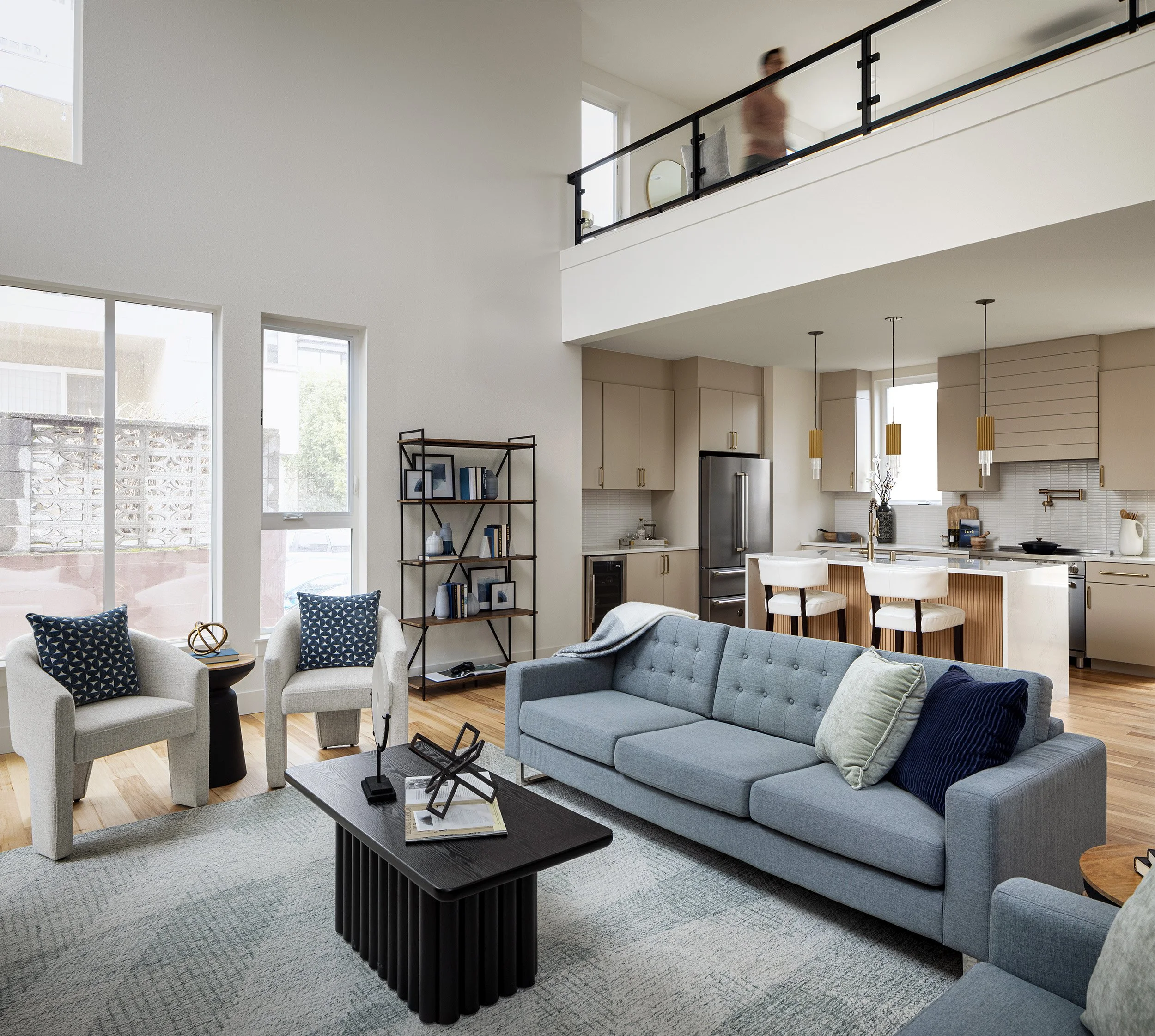 Open concept residential living room and kitchen with double height ceiling and mezzanine, Seattle interior photography by Mike Arty