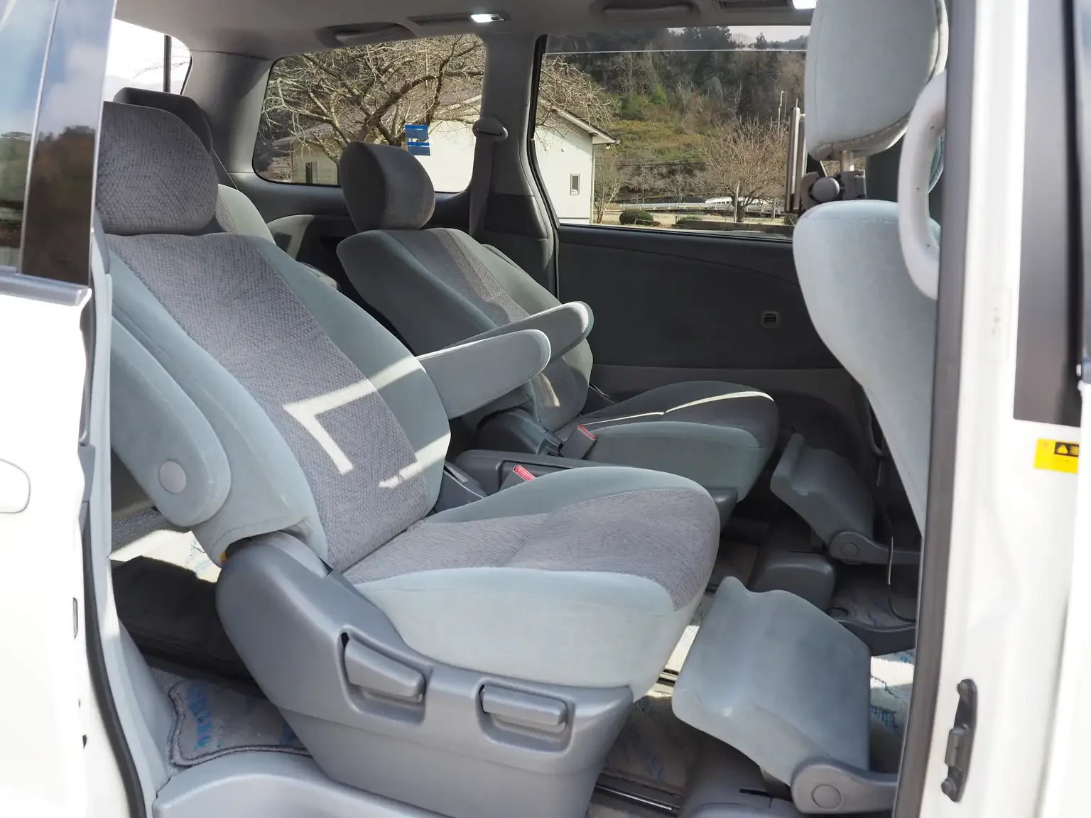Interior shot of 2nd row seat in grey reclined with ottoman foot rests in service 2001 Toyota Estima Aeras L Japan export inventory for sale