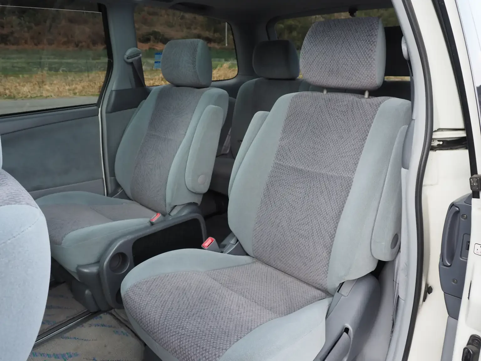 Interior shot of middle row captains chairs in 2001 Toyota Estima Aeras L with grey JDM export inventory for sale
