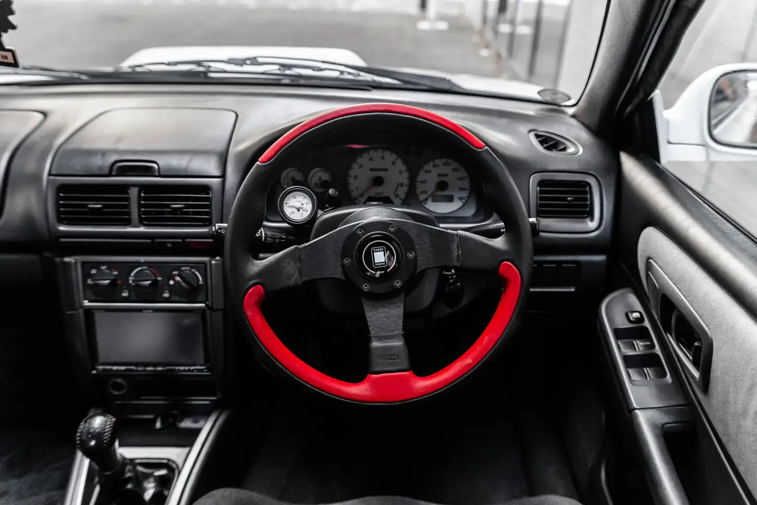 low milage interior showing dash and aftermarket red and black nardi steering wheel gc8 subaru impreza WRX STi version 4 1998 JDM vehicle for export sale New Zealand