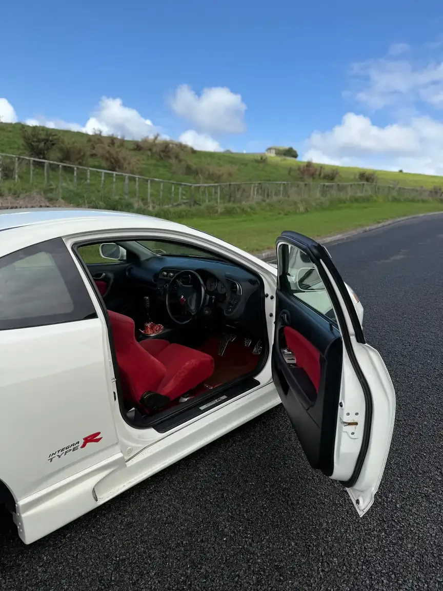 Drivers door open white 2001 DC5 Honda Integra Type R showing red Recaro seat and interior JDM export vehicle for sale New Zealand