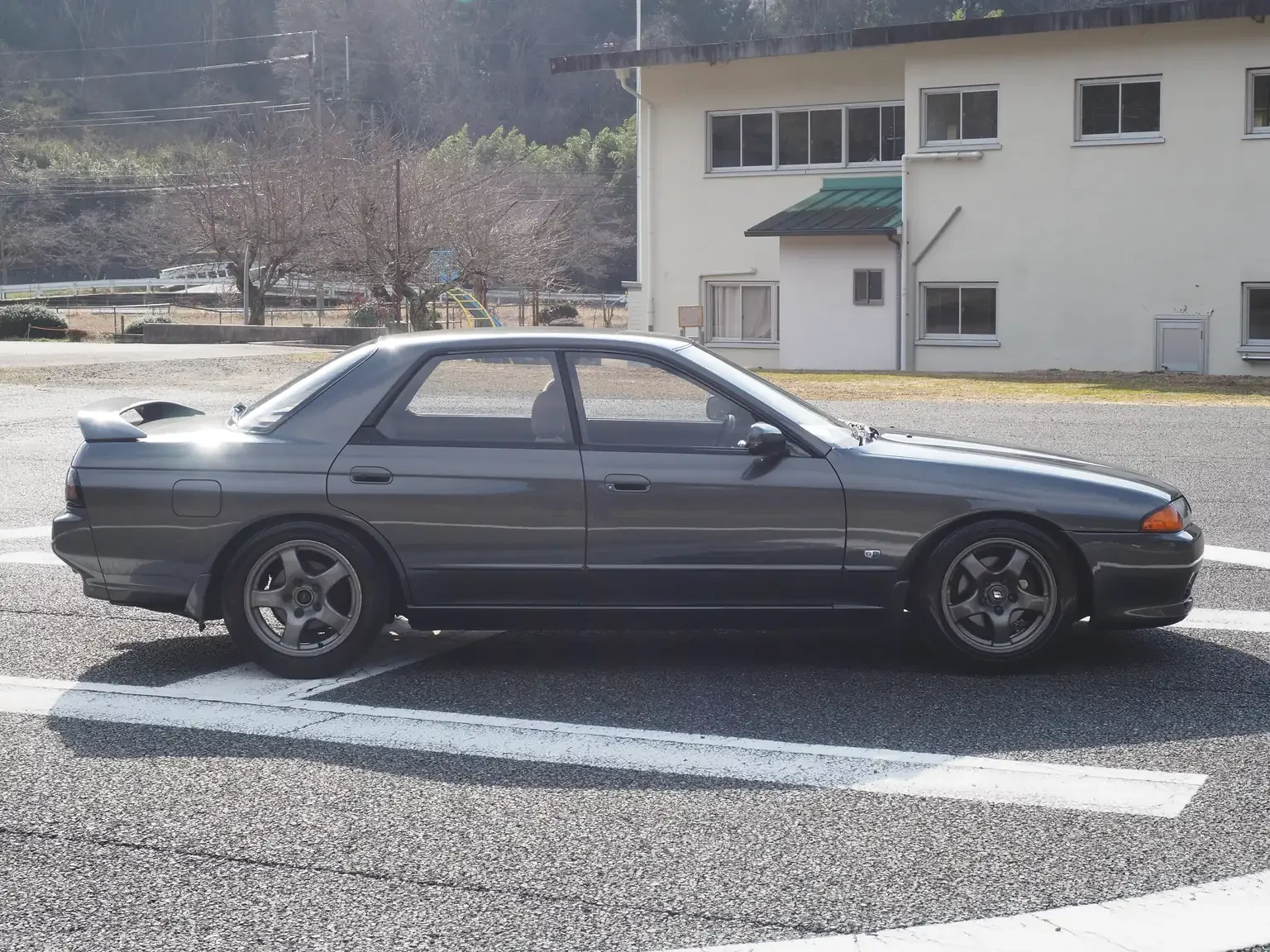 Drivers side on view gun metal grey 1991 Nissan Skyline GTS25 Type X G 4 Door Sedan for export from Japan