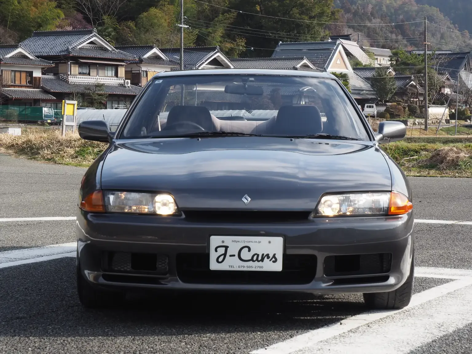 Front end view of a grey 1991 Nissan Skyline GTS25 Type X G 4 Door Sedan for export from Japan