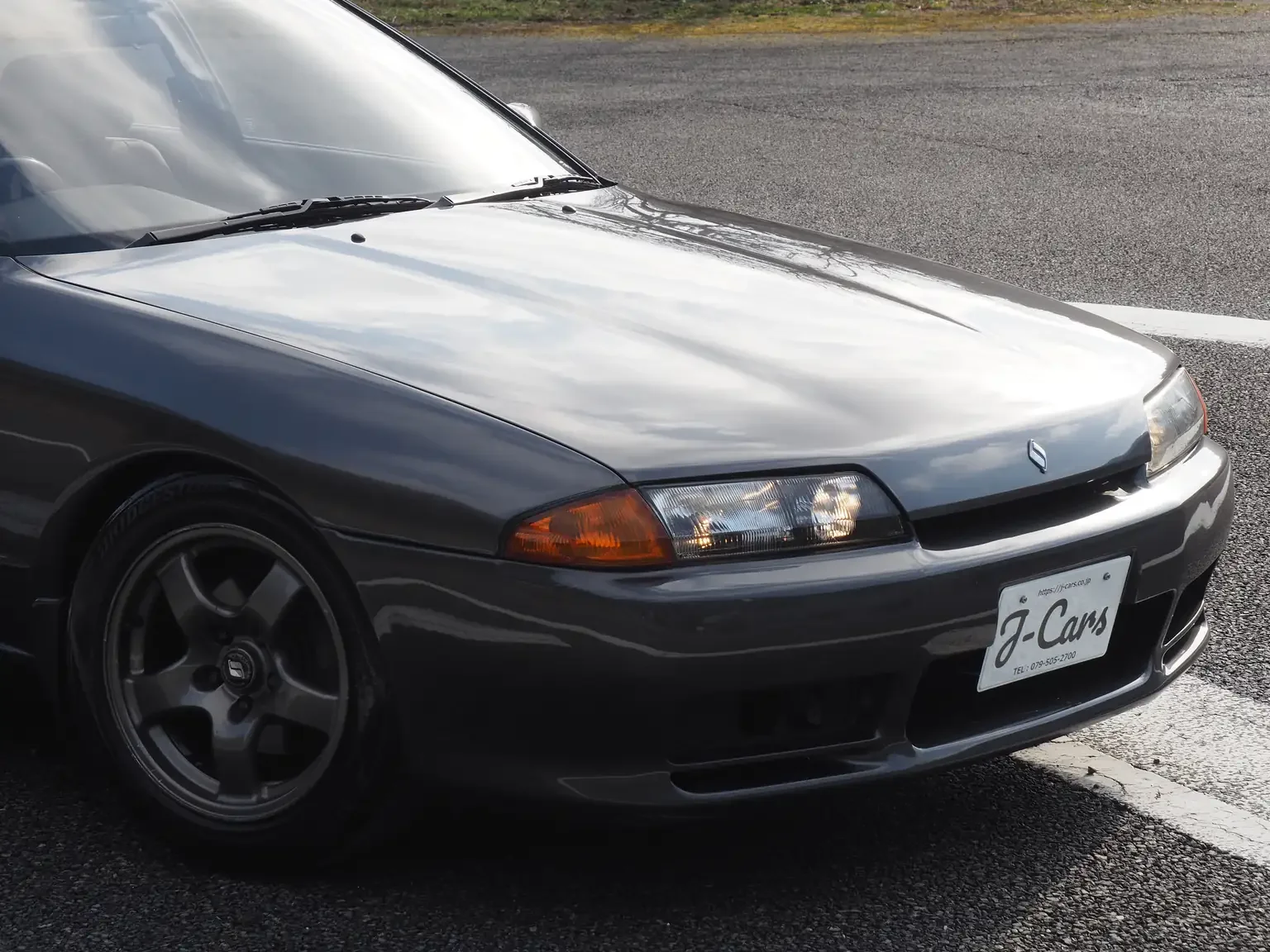 Front drivers front end quarter view of a grey 1991 Nissan Skyline GTS25 Type X G 4 Door Sedan for export from Japan