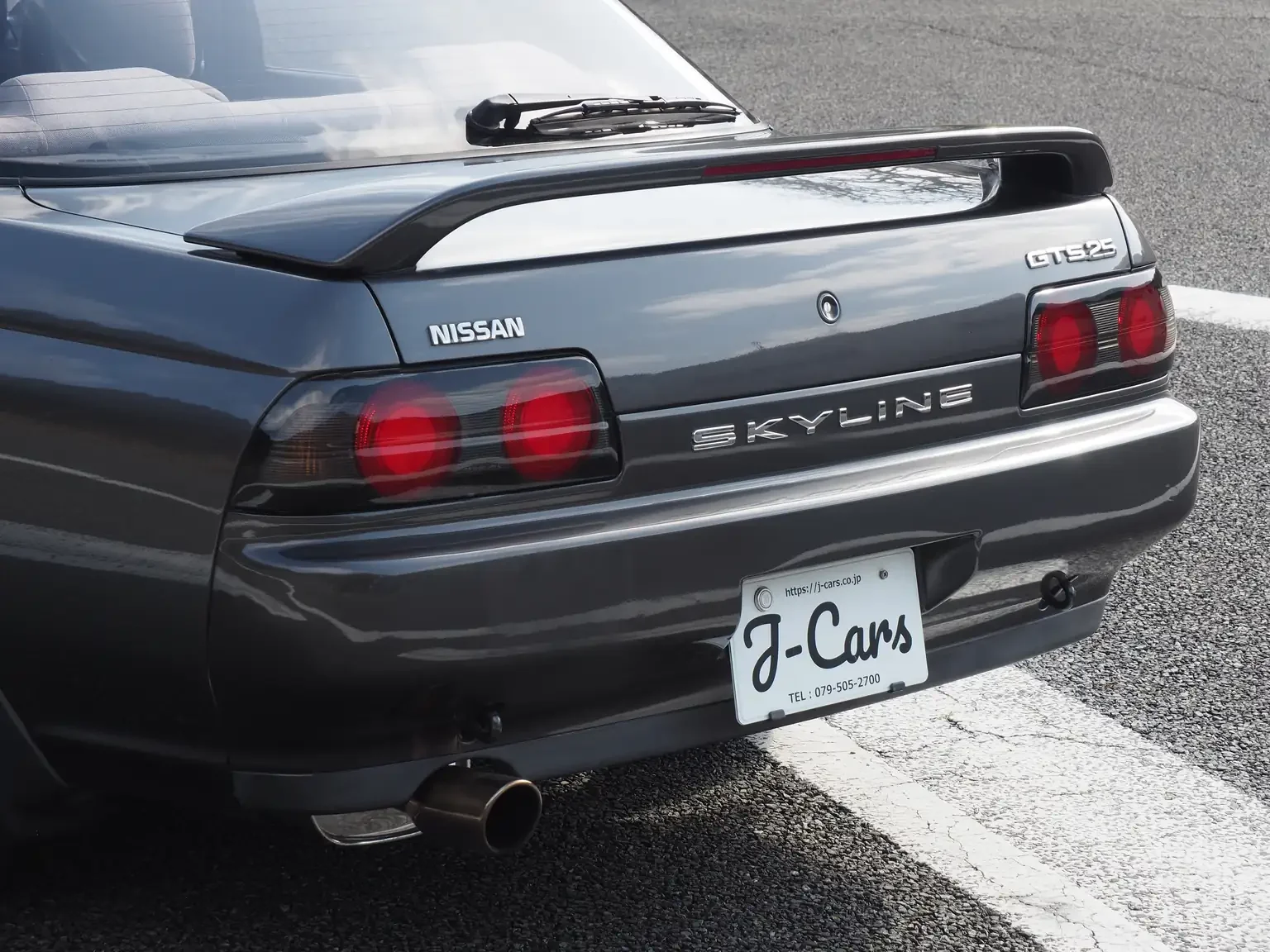 Rear trunk and spoiler view of a grey 1991 Nissan Skyline GTS25 Type X G 4 Door Sedan for export from Japan