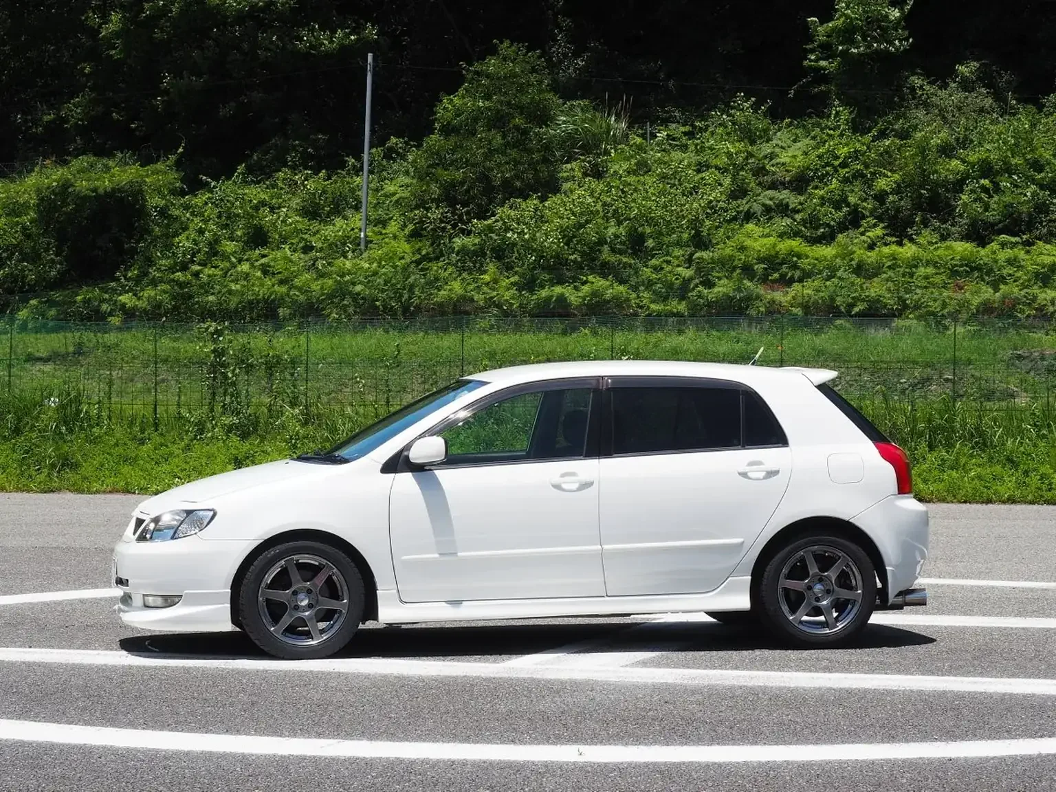 passengers side view modified white toyota corolla runx aero tourer z 6 speed zze123 JDM export stock for sale japan