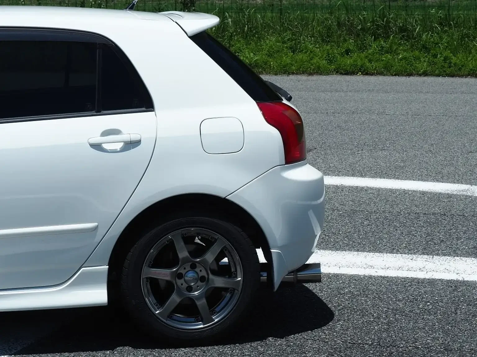 rear quarter view modified white toyota corolla runx aero tourer z 6 speed zze123 JDM export stock for sale japan