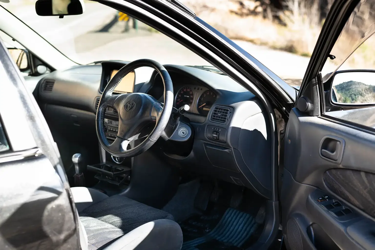 drivers door open showing interior view toyota sprinter carib bz touring 4age 6MT black usa legal jdm vehicle with title for sale colorado USA