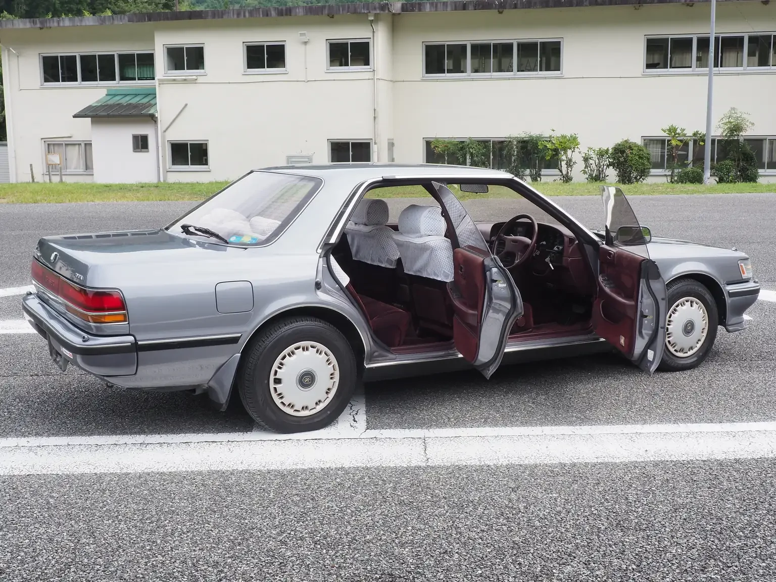rear passengers side angle shot with doors open showing wine red interior grey 1990 toyota chaser gx81 jdm export stock japan