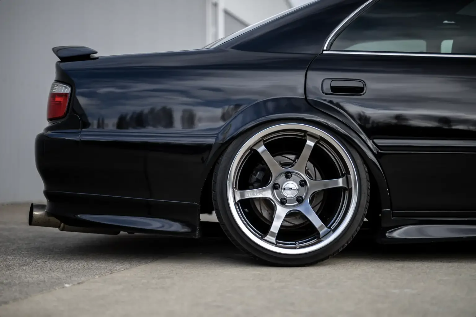 rear half end view view black toyota chaser tourer v jzx100 custom steel wide body jdm export vehicle new zealand