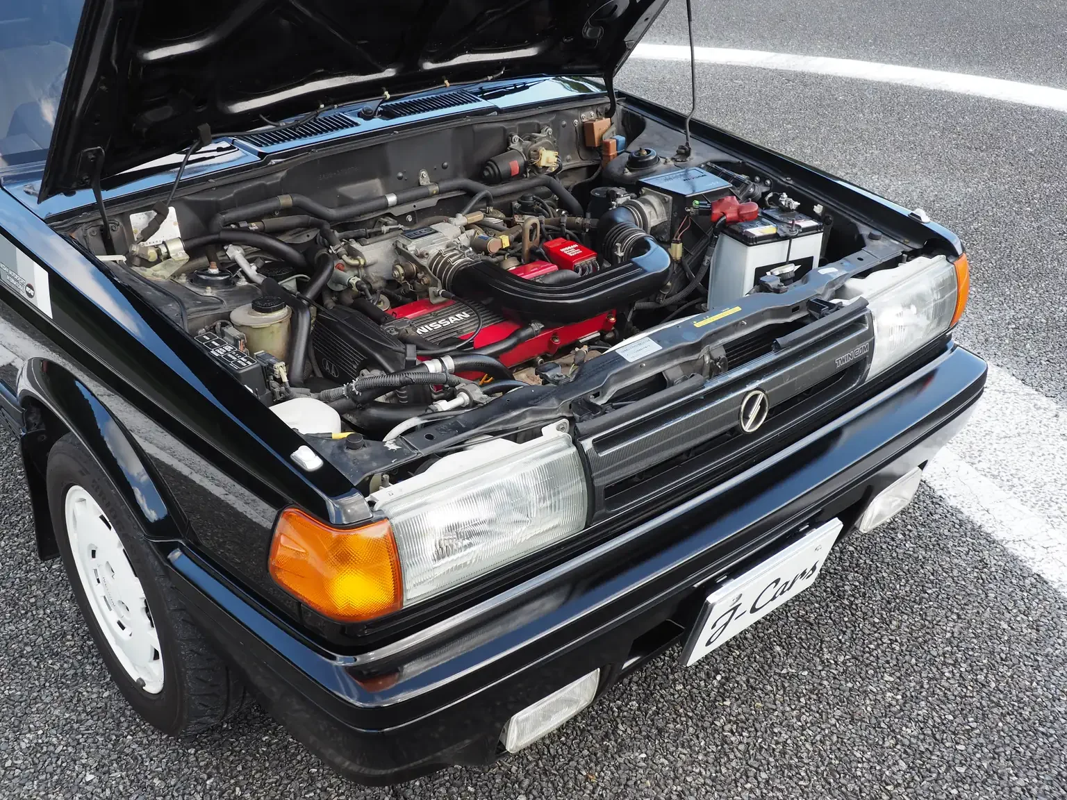 bonnet open showing ca16de red top engine view of 1989 Nissan sunny super saloon twin cam NISMO in black jdm export vehicle Japan