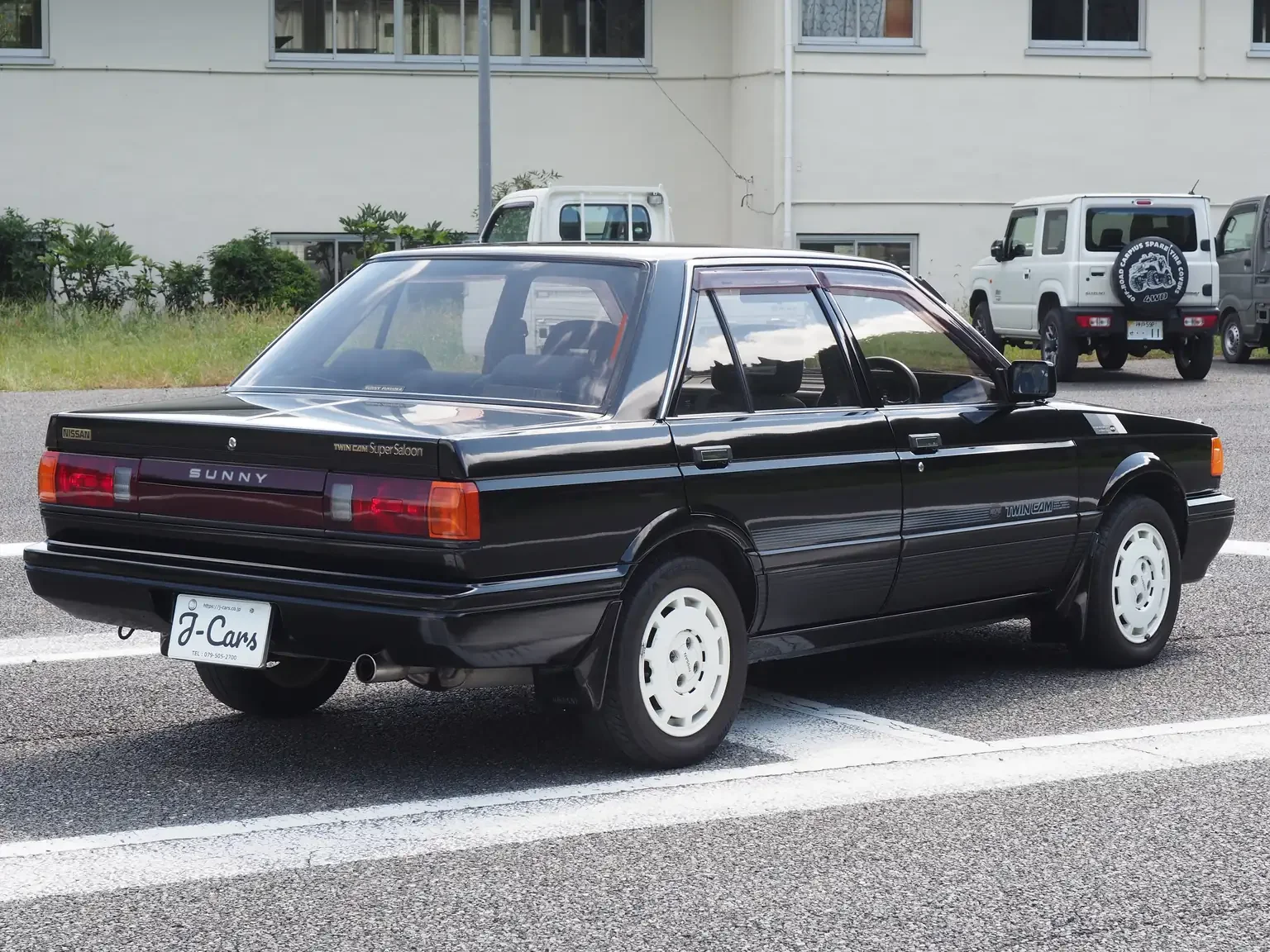 rear drivers angle view of 1989 Nissan sunny super saloon twin cam NISMO in black jdm export vehicle Japan