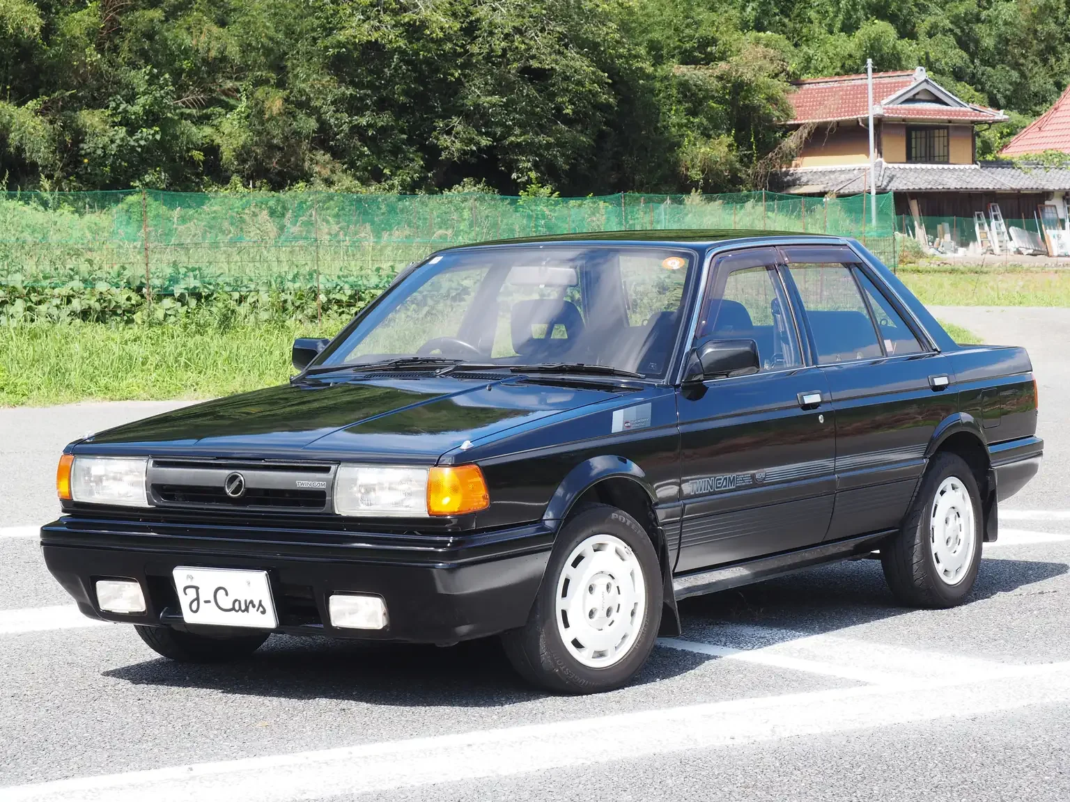front passengers angle view of 1989 Nissan sunny super saloon twin cam NISMO in black jdm export vehicle Japan