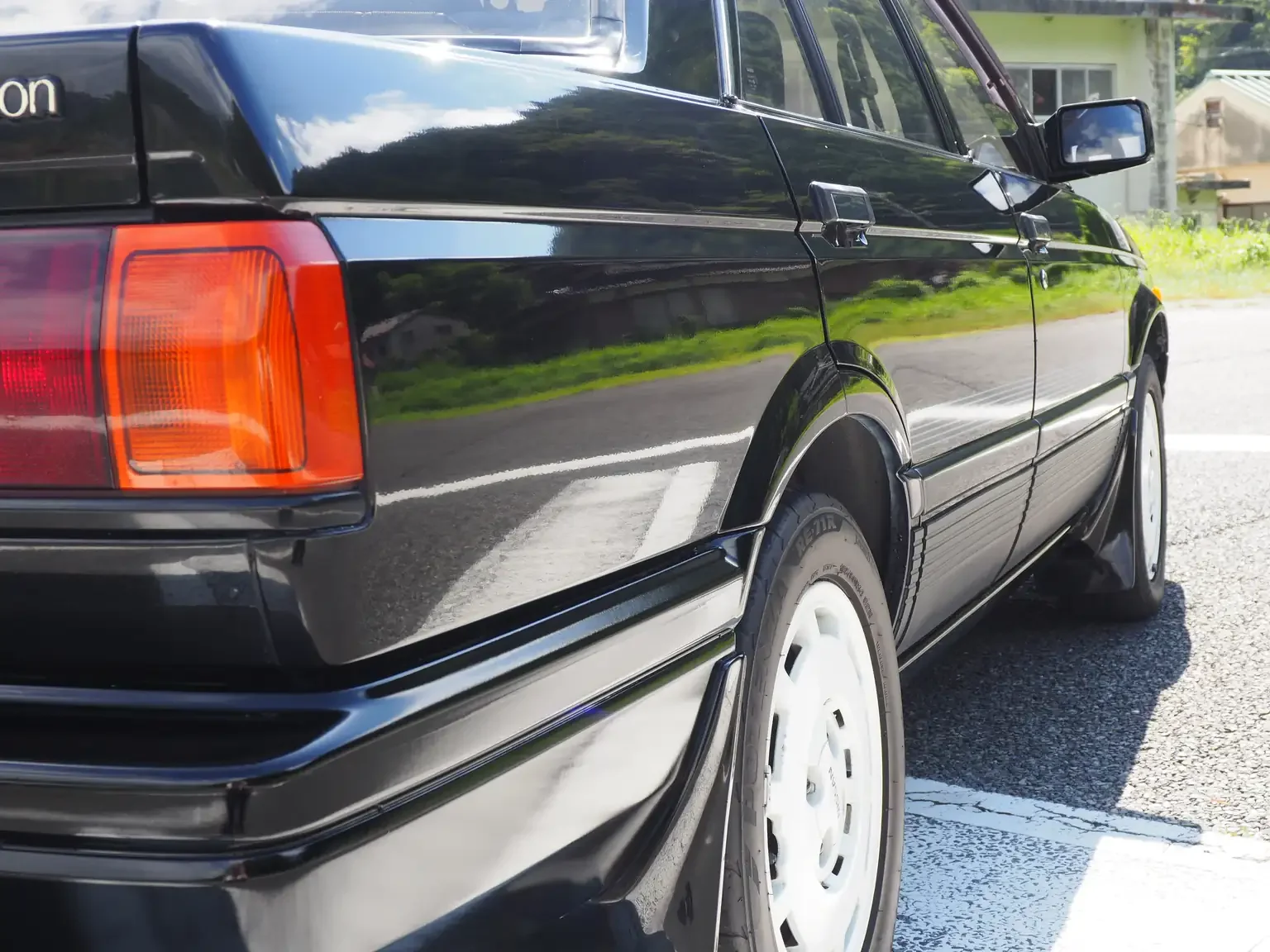 drivers side close up profile view view of 1989 Nissan sunny super saloon twin cam NISMO in black jdm export vehicle Japan
