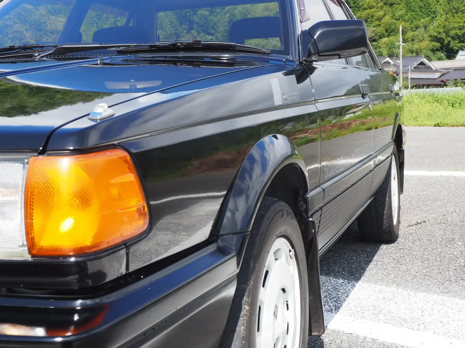 passengers side close up profile view view of 1989 Nissan sunny super saloon twin cam NISMO in black jdm export vehicle Japan