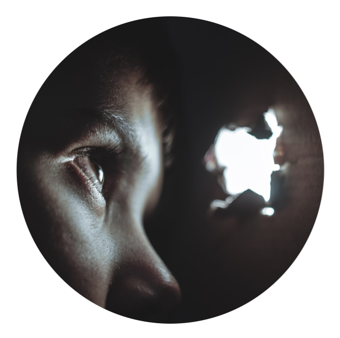 Person looking through crack at light