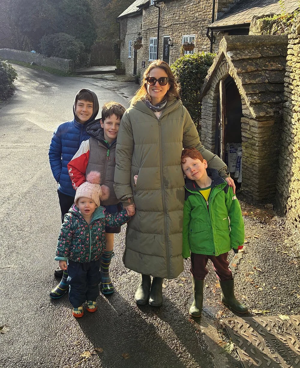 Pelvic health physiotherapist Claire Fitzpatrick standing smiling in a rural lane with her 4 children