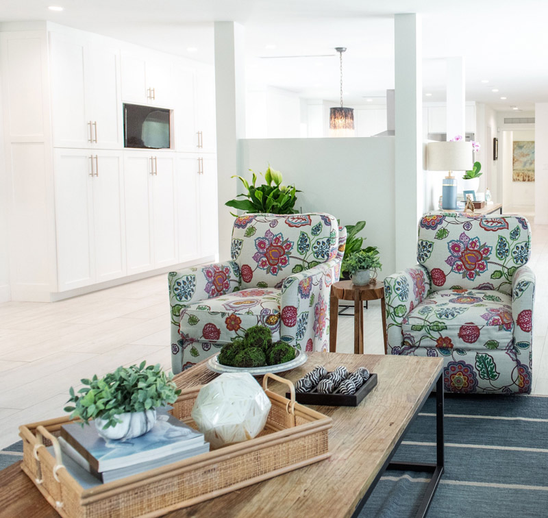 living-room-blue-rug-modern-farmouse-design-floral-swivel-armchair-gray-leather-sofa-decorative-pillow-geometric-curtains-cropped.jpg