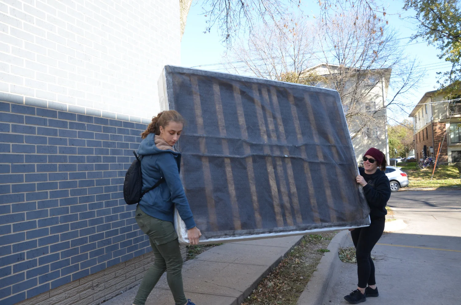 Volunteers carry a boxspring into a downtown Iowa City apartment.