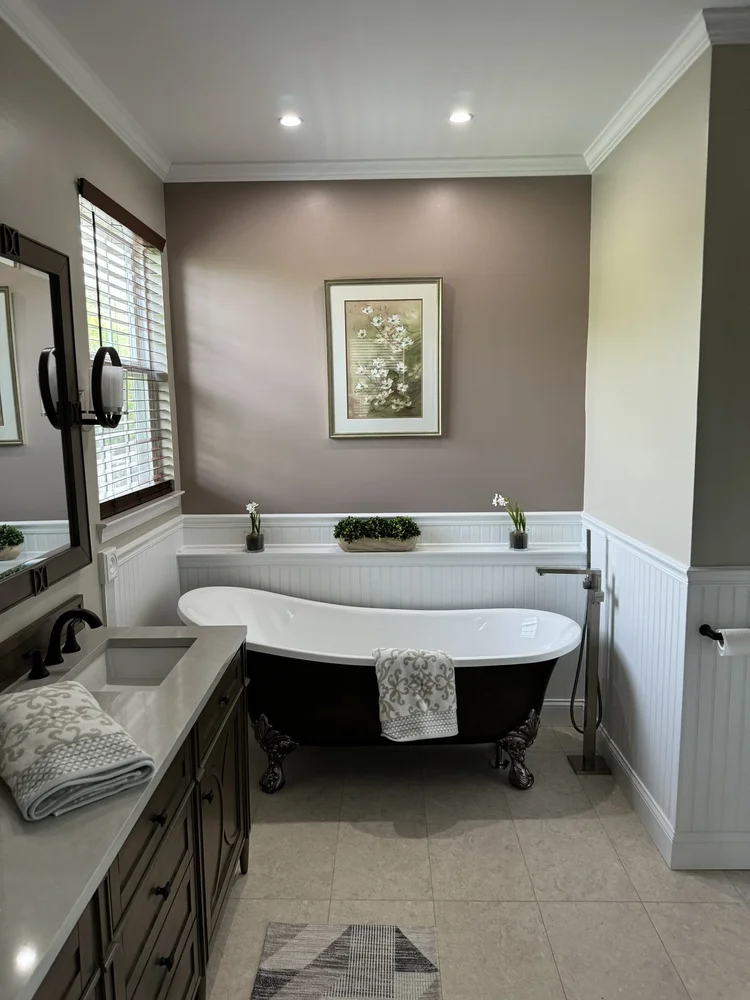 Remodeled bathroom with freestanding tub and wainscoting