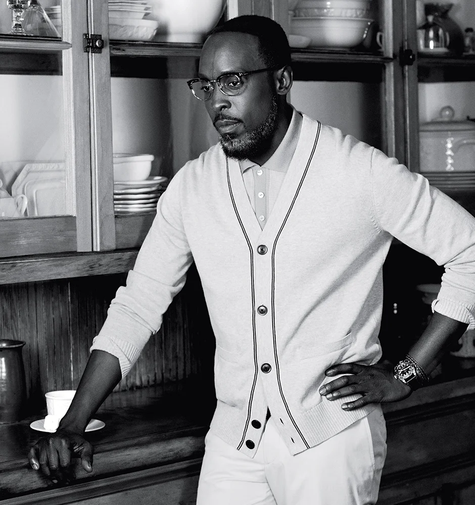 Salmon banlon polo shirt DAVID HART light blue cotton cardigan TOMMY HILFIGER sand cotton and wool canvas straight trousers HERMÈS black leather watch with black dial and burgundy bezel TUDOR black leather braided double wrap bracelet CAPUTO & CO. glasses OLIVER PEOPLES