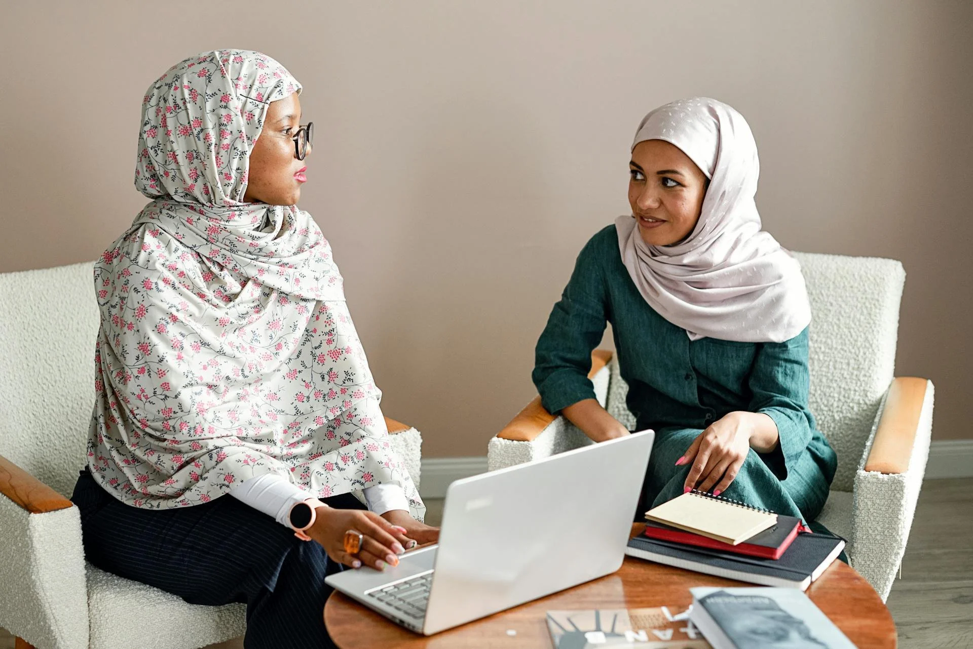 pexels-mikhail-nilov-8938287-Two Muslim women engaging in a meeting at an office space with laptops and notes..jpg