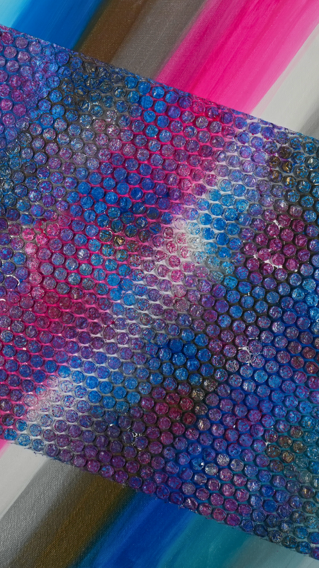 Into Space 1 - Textured painting with layers of pink, blue, black, gray, and white colors, with a sheet of colorful bubble wrap placed on top.